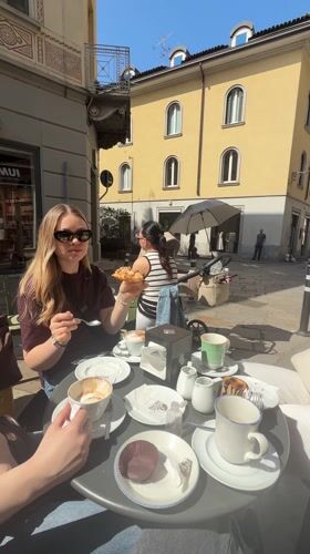 Women enjoy morning pastries at outdoor cafe in Lecco