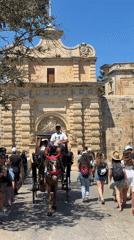 Tourists explore historic stone complex during midday visit