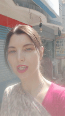 Woman takes selfie on sunny street