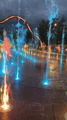 Walking through a colorful illuminated fountain display in Almaty
