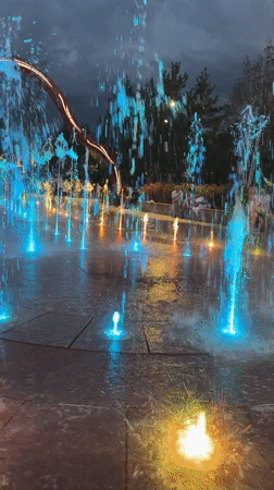 Walking through a colorful illuminated fountain display in Almaty