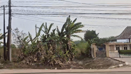 Street-level drive through a busy Timbangan market district