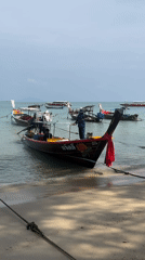 Longtail boats moored in calm water at Rawai beach