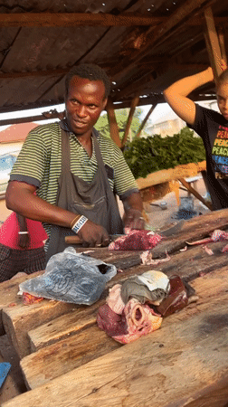 Butcher works cheerfully at meat shop in Abuja