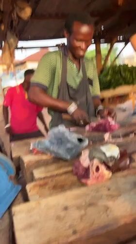 Butcher works cheerfully at meat shop in Abuja