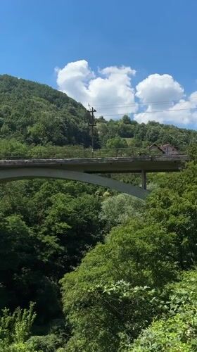 Cliff-side trail and concrete arch bridge near Užice, Serbia