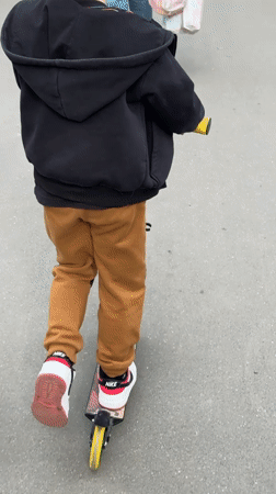 Child rides scooter on path in Tolyatti, Russia