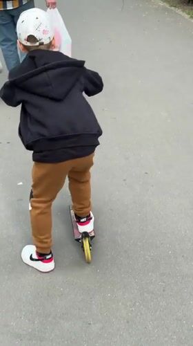 Child rides scooter on path in Tolyatti, Russia