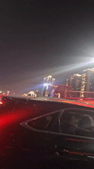 Vehicle crosses illuminated bridge in Yuzhong District at night