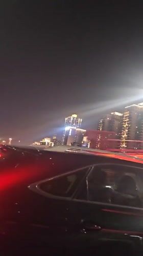 Vehicle crosses illuminated bridge in Yuzhong District at night