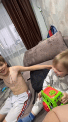Two boys share affectionate moment on couch in Noviy