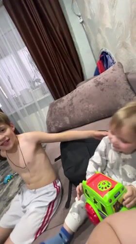 Two boys share affectionate moment on couch in Noviy