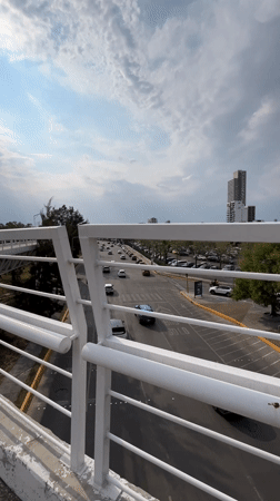 Evening pedestrian overpass views document commercial district in Puebla