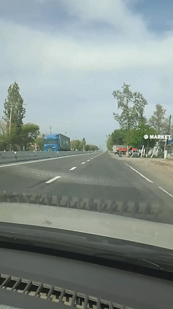 Dashboard view captures woman on Uzbekistan highway