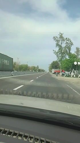 Dashboard view captures woman on Uzbekistan highway