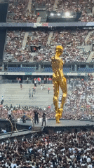 Giant golden humanoid figure dominates packed Saint-Denis stadium
