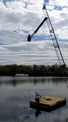 Construction crane operates over Moscow lake with harnessed operator