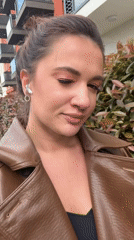 Woman in brown leather coat walks Belgrade street