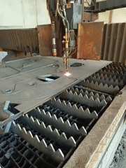 Industrial cutting machine processes metal sheet at factory workshop