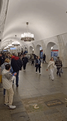 Morning commuters navigate ornate Moscow subway station platform