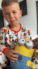 Morning playtime on a bed with a Minion toy and snacks