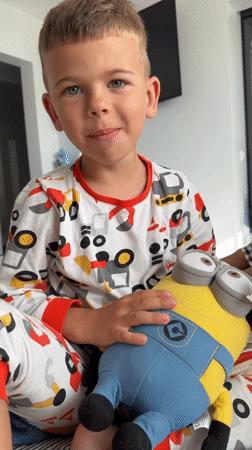 Morning playtime on a bed with a Minion toy and snacks