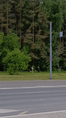 Woman runs alongside road as traffic passes in Perm