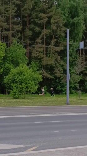 Woman runs alongside road as traffic passes in Perm