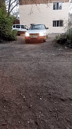 Construction, cars, and a cat in a dusty Semey lot