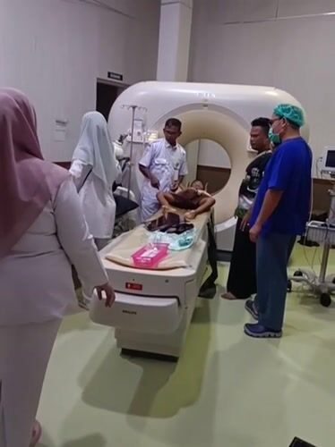 CT scan in progress alongside sunny outdoor grounds in Mesjid Reuntoh