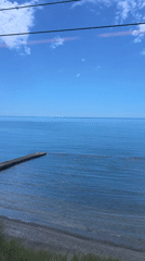 Train passenger films calm waters and concrete pier in Sochi