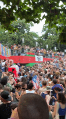 Outdoor crowd dancing at colorful stage event in New York