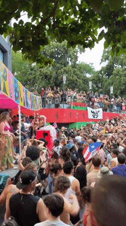 Outdoor crowd dancing at colorful stage event in New York