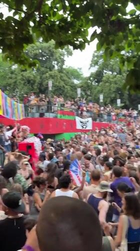 Outdoor crowd dancing at colorful stage event in New York