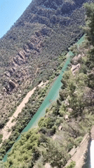 Turquoise river flows through lush mountain valley, witness reports