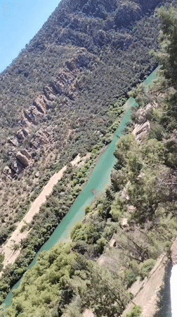 Turquoise river flows through lush mountain valley, witness reports