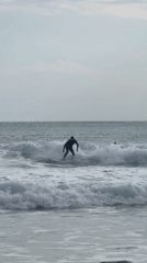 Surfer enjoys session at Hout Bay under overcast skies