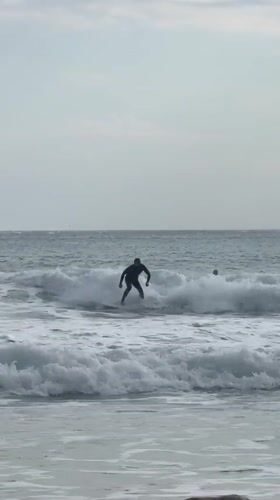 Surfer enjoys session at Hout Bay under overcast skies