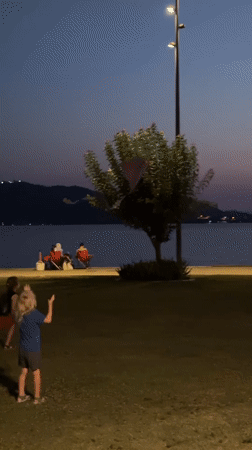 Dusk at Fethiye waterfront, kids on the grass, sky glowing