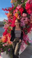 Moscow waterfront sees casual afternoon activity, woman poses among flowers
