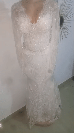 Ornate white wedding dress displayed on mannequin captured