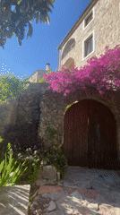 Tourist photographs historic architecture and flowers in Budva, Montenegro