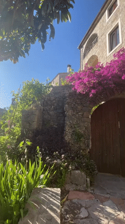 Tourist photographs historic architecture and flowers in Budva, Montenegro
