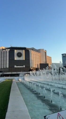 Juggling and fountains outside Sofia's NDK at golden hour