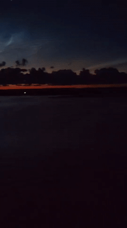 Dusk over open water, sky fading from blue to orange