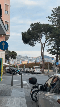 Elderly couple walks Sanremo streets under cloudy skies
