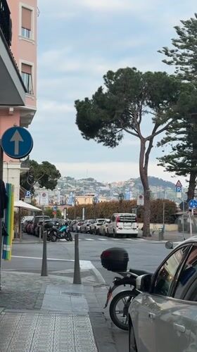Elderly couple walks Sanremo streets under cloudy skies