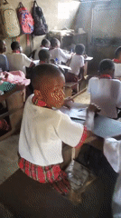 African students in red plaid uniforms attend school classes