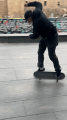 Skateboarders practice tricks in Barcelona public square amid city activity