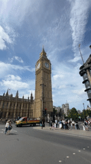 Tourists photograph Big Ben and Parliament under cloudy London skies